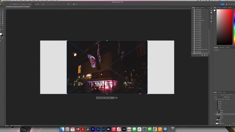 A screenshot of Adobe Photoshop with a nighttime city photo being edited. The image shows a street scene with UK flags and a brightly lit storefront, centered and enlarged on the Photoshop workspace.