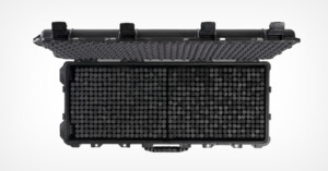 A black hard-shell protective case with an open lid, revealing a grid of cylindrical compartments inside. The lid has egg crate foam padding for cushioning contents.