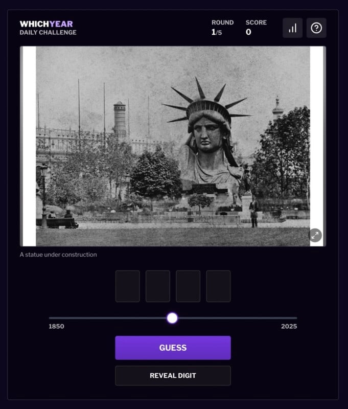 A black-and-white photo shows the head of the Statue of Liberty under construction in a park, surrounded by trees and buildings. The year guessing game interface is visible below the image.